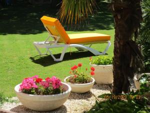a yellow chair sitting in a yard next to flowers at Locatlantique in Aytré