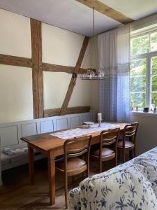 a dining room with a wooden table and chairs at Pfarrhof Stuer in Stuer