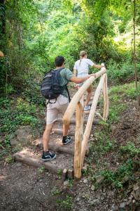 two people walking over a wooden bridge on a trail at Park Hotel Abbadia in Abbadia Lariana