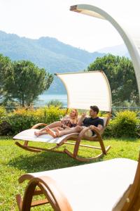 a man and a woman sitting on a chair at Park Hotel Abbadia in Abbadia Lariana