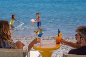 a group of people sitting at a table on the beach at Poseidon The Beach Hotel in Budva