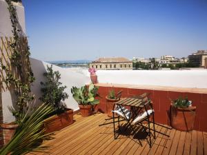 une terrasse en bois avec un banc et des plantes en pot dans l'établissement L'Approdo delle Sirene, à Syracuse