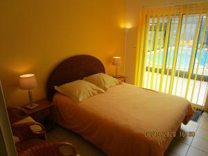 a bedroom with a bed with a large window at Locatlantique in Aytré