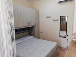 - une petite chambre avec un lit et des armoires dans l'établissement IL RIFUGIO in VALLE D'ITRIA, à Locorotondo