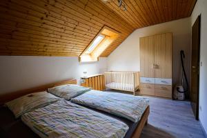 Bad Rippoldsau-SchapbachにあるFerienwohnung Am Sulzbächleの木製の天井のベッドルーム1室(ベッド1台付)