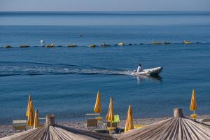 a man in a boat in the water near a beach at Poseidon The Beach Hotel in Budva