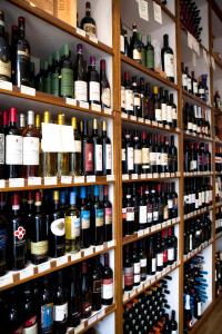 un montón de botellas de vino en estanterías en una tienda en Number 10 Locanda B&B en Belvedere Langhe