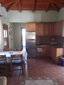 a kitchen with a table and a stainless steel refrigerator at AGIOS NIKITAS DOLPHINS in Agios Nikitas