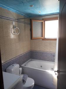 a bathroom with a tub and a toilet and a sink at AGIOS NIKITAS DOLPHINS in Agios Nikitas