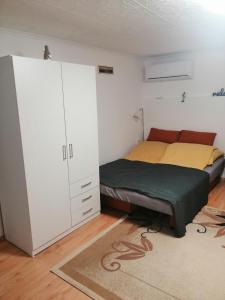 ein Schlafzimmer mit einem Bett, einem Schrank und einem Teppich in der Unterkunft Nagymackó Kuckója in Keszthely