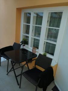 einen Tisch und Stühle in einem Zimmer mit Fenster in der Unterkunft Nagymackó Kuckója in Keszthely