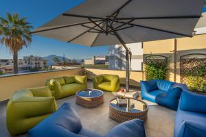 un patio con sofás, una mesa y una sombrilla en DON GIULIO LUXURY ROOMS jacuzzi & pool, en Vico Equense