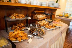 a buffet line with bread and pastries on a table at Park Hotel Abbadia in Abbadia Lariana