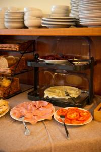 a table with plates of food and utensils at Park Hotel Abbadia in Abbadia Lariana