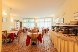 a restaurant with tables and chairs with red bows at Park Hotel Abbadia in Abbadia Lariana
