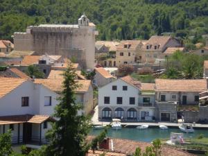 a town with a castle and boats in the water at Villa Welcome in Vrboska