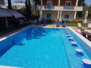 a swimming pool with blue chairs and a house at Laida studios in Prinos