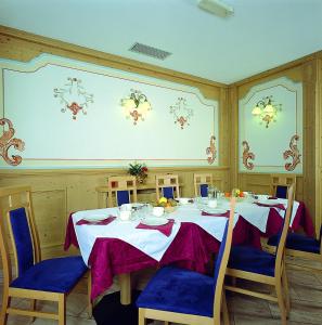 una sala da pranzo con tavolo e sedie blu di Hotel Al Plan Andalo ad Andalo