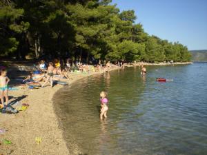 a young girl standing in the water at a beach at Villa Welcome in Vrboska