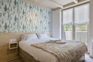 1 dormitorio con 1 cama grande y ventana grande en Luderna - Apartamento con jardín Bela, en Vielha
