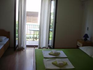 a bedroom with two beds and a large window at Villa Welcome in Vrboska