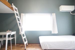 a bedroom with a ladder and a bed and a window at Plusone Nishikoen in Fukuoka