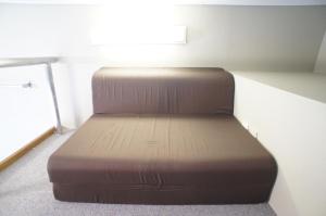 a brown bed in a room with a window at Plusone Nishikoen in Fukuoka