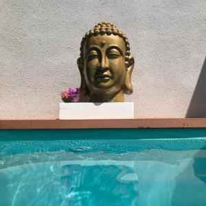 uma estátua de Buda de Ouro ao lado de uma piscina em Apartments LOTA on TOP Location em Supetar