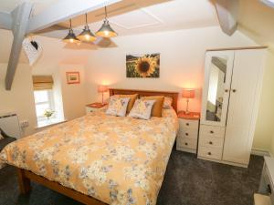 1 dormitorio con cama y espejo en Garnedd, en Holyhead