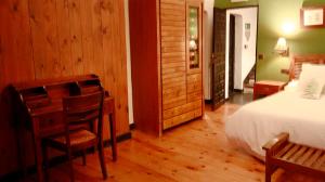 a bedroom with a bed and a desk and chairs at Casona De Navalmedio in Cercedilla