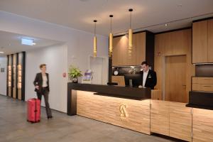 a man and a woman standing in a lobby at Hotel Restaurant Clemens-August in Ascheberg