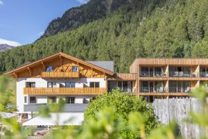 a large building with a mountain in the background at Almhotel Glieshof in Malles Venosta