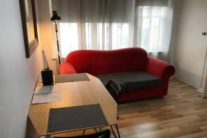 a living room with a red couch and a table at ShelleyStayz Park St in Melbourne