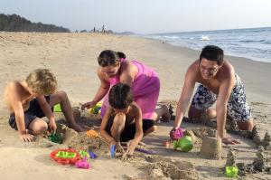 a group of people playing in the sand on the beach at Heritage Village Resort & Spa Goa in Cansaulim