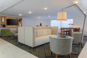 a living room with a couch and chairs and a table at Holiday Inn Express Milwaukee - West Medical Center, an IHG Hotel in Wauwatosa