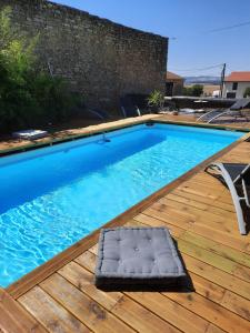a swimming pool with a mattress on a wooden deck at Parenthèse à la campagne in Alaincourt-la-Côte