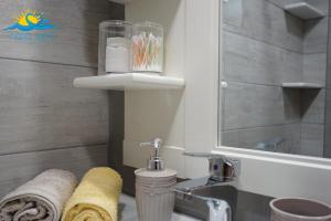 un bagno con lavandino, WC e specchio di Casa Vista Spring a Karpathos Altre 14 foto