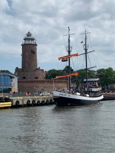 Ein Piratenschiff ist neben einem Leuchtturm angedockt. in der Unterkunft Apartament 454 w hotelu Diva in Kołobrzeg