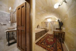 a door to a room with a bed and a bathroom at Walnut House in Göreme