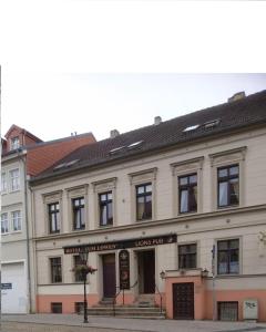 a large white building on a city street at Hotel-Garni "Zum Löwen" in Bad Freienwalde