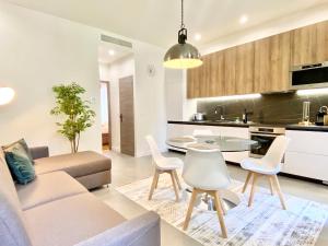 uma sala de estar com um sofá, uma mesa e cadeiras em Maxim - Easy Home Booking em Nice