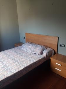 1 dormitorio con cama y cabecero de madera en Apartamento, en Padrón