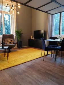 un soggiorno con tappeto giallo, tavolo e sedie di Apartment Sea Promenade - Opatija center a Opatija