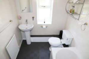 a white bathroom with a toilet and a sink at Elmfield House in Bedale