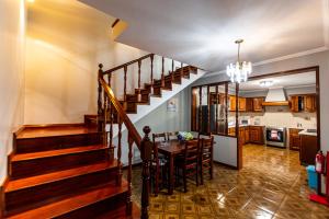 a dining room and kitchen with a staircase in a house at Casa do Pescador SBMP-2 in Faial da Terra