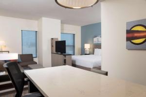 a hotel room with a bed and a table and a room at Hyatt House Austin/Downtown in Austin