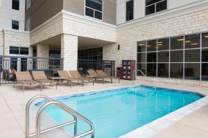 a swimming pool with chairs and a building at Hyatt House Austin/Downtown in Austin