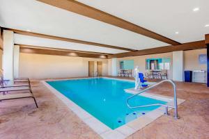 una grande piscina in una stanza con sedie e tavoli di La Quinta Inn & Suites by Wyndham Northlake Ft. Worth a Northlake