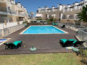 a swimming pool on a wooden deck with two lounge chairs at Penthouse Ria in Santa Luzia