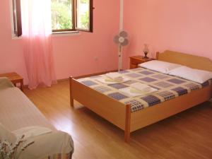 a bedroom with a bed and a fan at Villa Welcome in Vrboska